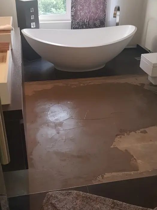 Badezimmer mit freistehender Badewanne während der Bodensanierung – Untergrund für Parkett im Bad vorbereitet.
